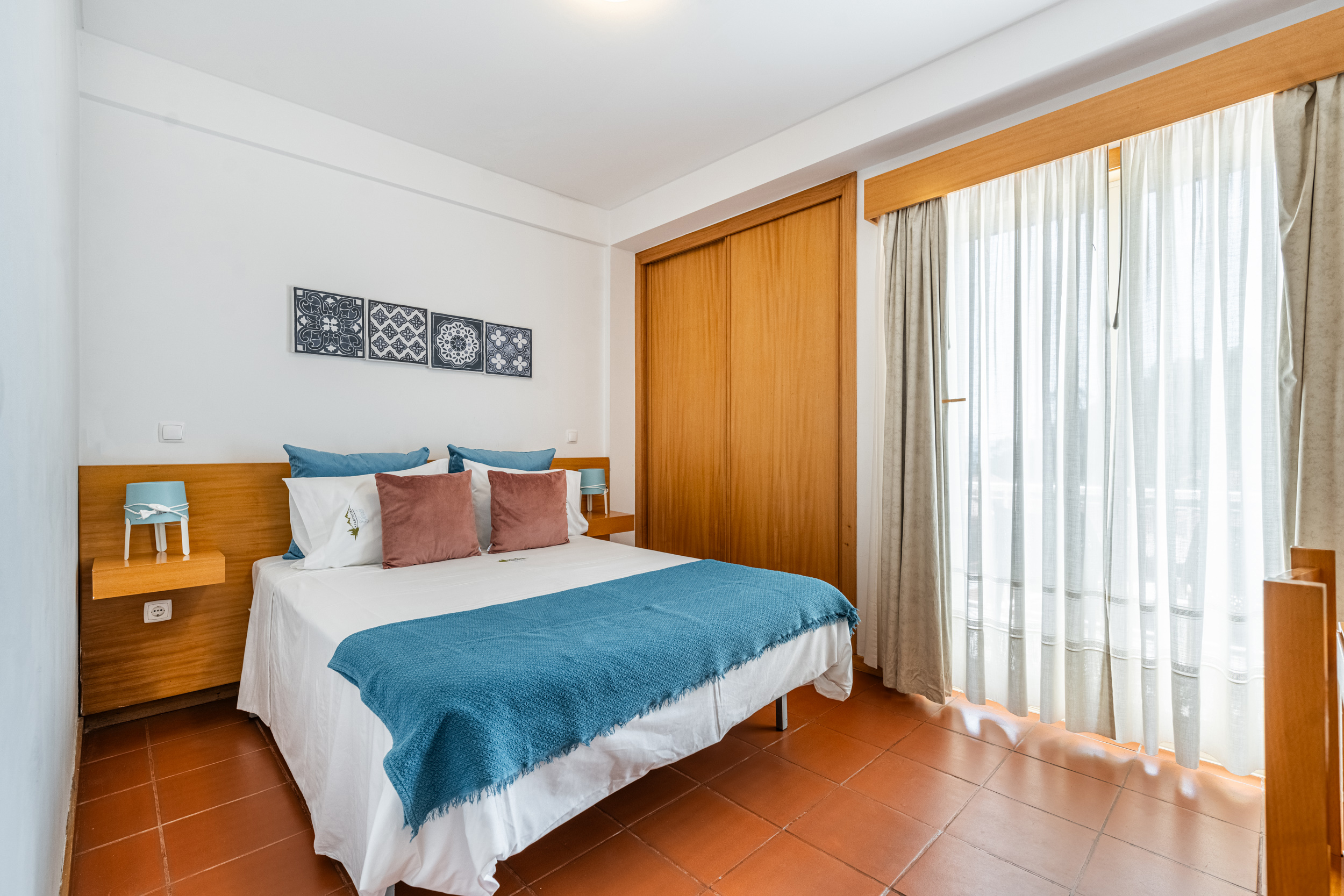 Quarto com cama de casal e tons azul-turquesa