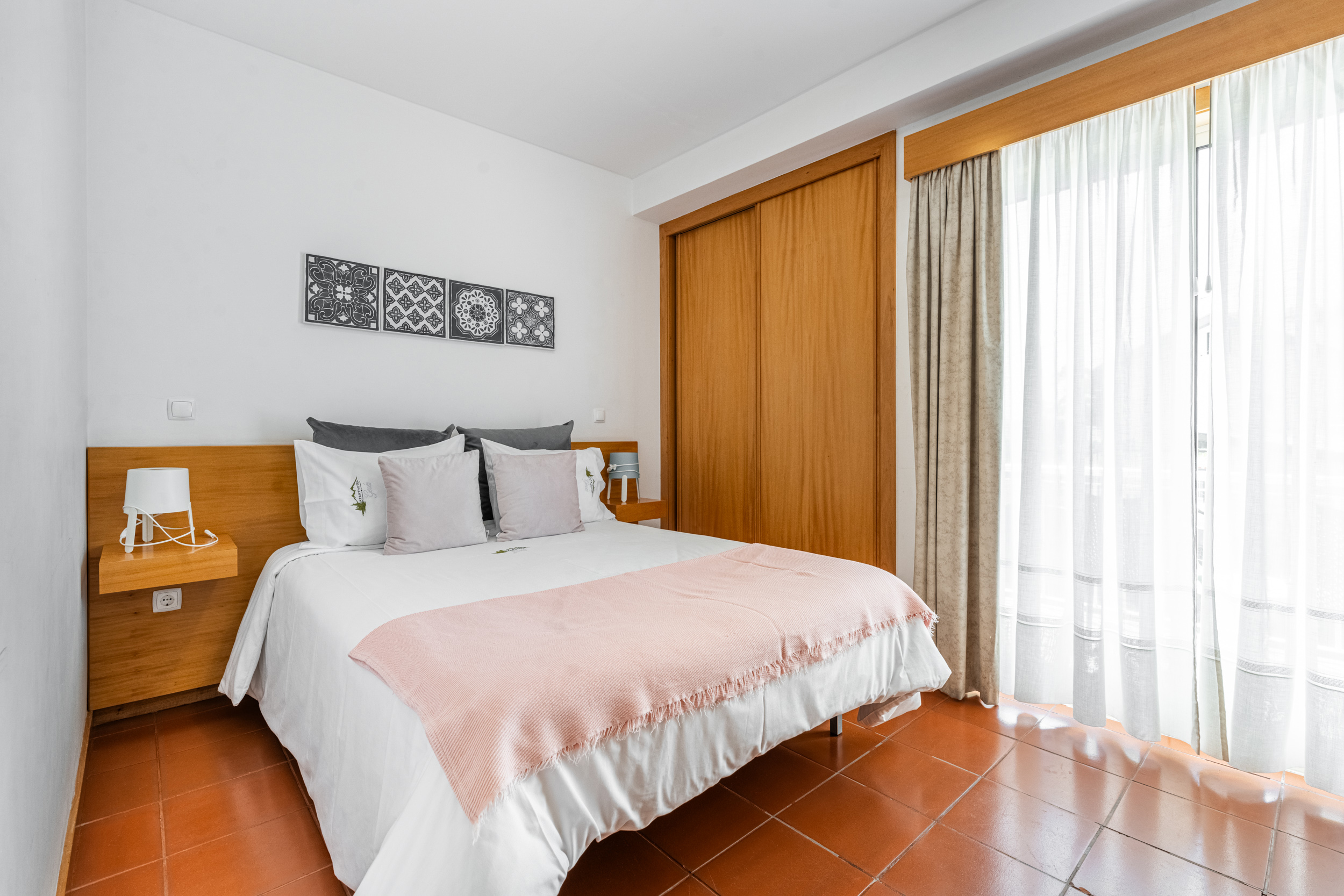 Quarto principal com cama de casal e azulejos decorativos